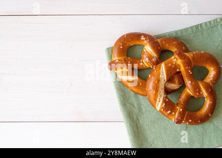 Zwei frisch gebackene Brezeln auf einem schlichten Hintergrund, die den festlichen Geist des Oktoberfestes und die traditionelle deutsche Küche erinnern Stockfoto