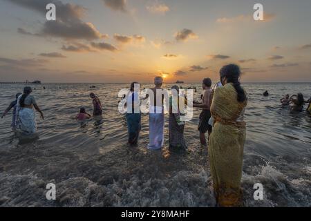 Hinduistische Pilger nehmen bei Sonnenaufgang ein heiliges Bad im Meer in Ghat Agni Theertham, Rameswaram oder Rameshwaram, Pamban Island, Tamil Nadu, Indien, Asien Stockfoto