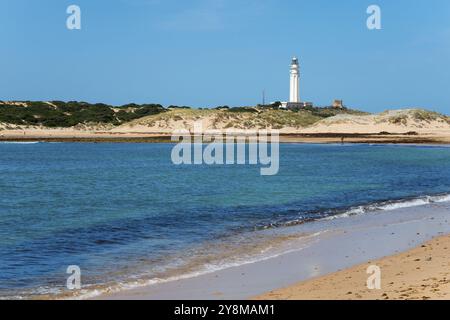 Sandstrand mit Leuchtturm im Hintergrund, klares blaues Meer und helle Dünen, Faro de Trafalgar, Cape Trafalgar, Provinz Cadiz, Costa de la Stockfoto