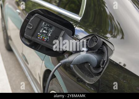Elektroauto wird an der Ladestation aufgeladen, Ladekabel an schwarzes Fahrzeug angeschlossen, Baden-Württemberg, Deutschland, Europa Stockfoto