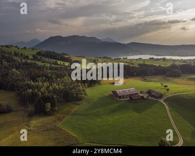 Ein Bauernhof in den Schweizer Alpen, fotografiert aus der Luft bei Sonnenuntergang Stockfoto