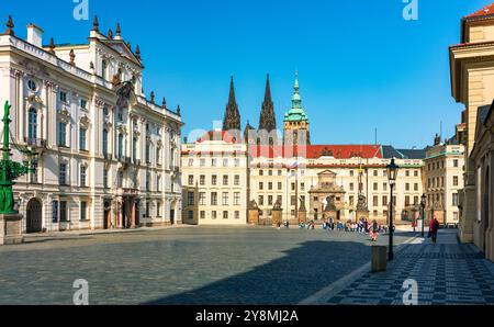 Die kopfsteingepflasterte Straße schlängelt sich durch historische Gebäude in Prag mit dem Veitsdom. Die Straße führt vorbei an historischen Gebäuden in Prag und zeigt Stockfoto