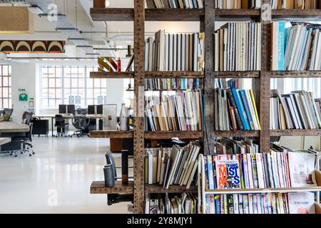 Bücherregal aus wiederaufbereitetem Holz im Büro von Mother Agency im Biscuit Building, ehemaliges Lipton Tea Warehouse, Shoreditch, London, England Stockfoto