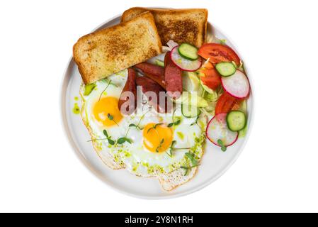 Gesundes englisches Frühstück mit Spiegeleiern, Würstchen, Toast und Salat in weißer Platte auf weißem Hintergrund Stockfoto