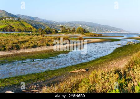 Blick auf das fließende Wasser in der Malibu Lagune, umgeben von üppigem Grün und Hügeln an einem sonnigen Frühlingstag. Stockfoto