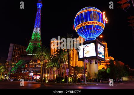 Las Vegas, Nevada - 13. April 2024: Ikonischer Eiffelturm-Nachbau und beleuchteter Ballon des Pariser Hotels auf dem Las Vegas Strip bei Nacht, umgeben von lebhaften Attraktionen Stockfoto