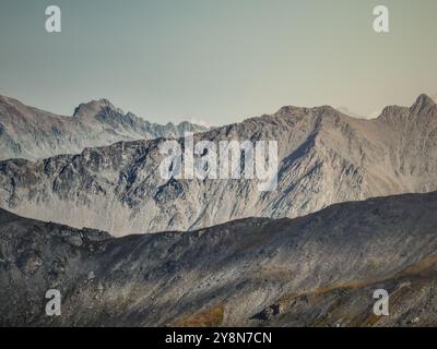 Drohnenblick auf die Savognin Berge in der Schweiz bei Sonnenuntergang mit Blick auf zerklüftete Gipfel und Täler, die in goldenes Licht getaucht sind Stockfoto