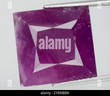 Exquisiter natürlicher Amethyst-Edelstein mit quadratischem Schliff, mit satten violetten Tönen und komplexer Klarheit. Stockfoto