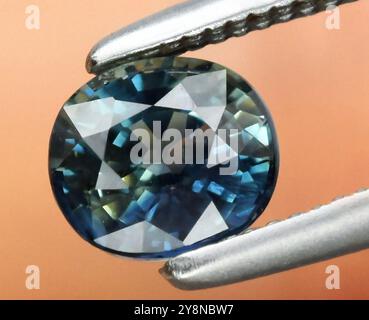 Exquisiter Naturstein im ovalen Schliff in ruhigen Blau- und Grüntönen mit brillanten Facetten. Stockfoto