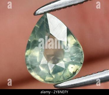 Exquisiter tropfenförmiger natürlicher grüner Edelstein mit facettierter Oberfläche. Stockfoto