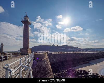 Der Leuchtturm am westlichen Pier mit der Abbey und der St. Mary's Church im Hintergrund Whitby Stockfoto