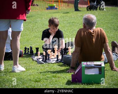 Kinder und Erwachsene spielen Schach auf dem Gras, Großbritannien Stockfoto