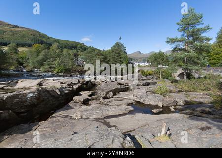 Dorf Killin, Schottland. Malerischer Blick auf die Fälle von Dochart mit Dochart Bridge im Hintergrund. Das Ben Lawers National Nature Reserve an Stockfoto