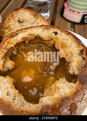 Rindergulasch-Suppe in Brotschale, serviert in einem Prager Stadtrestaurant, Tschechische Republik, 2024 Stockfoto