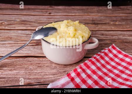 Eine Hand schöpft flauschige Kartoffelpüree aus einer Schüssel und zeigt die Wärme der Familientreffen am Thanksgiving Day Stockfoto