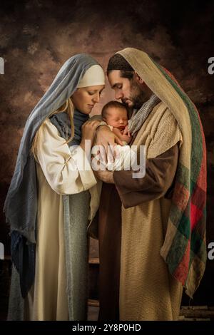 Stolze Eltern bei der Nachstellung einer Weihnachtskrippe mit ihrem eigenen 8 Tage alten Baby Stockfoto