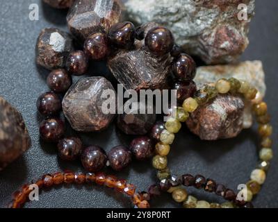 Almandine- oder Almanditsteine und Armbänder aus ihnen, selektiver Fokus. Granatmineralien Stockfoto