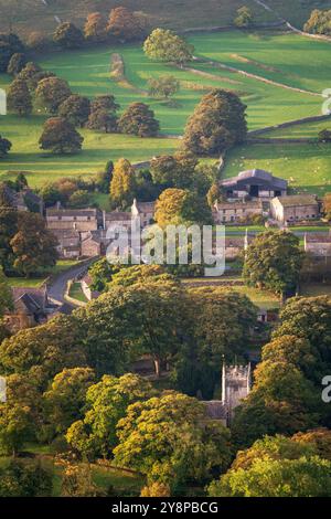 St. Oswald's Church wird durch die aufgehende Sonne an einem wunderschönen Herbstmorgen im malerischen Dorf Arncliffe in den Yorkshire Dales hervorgehoben. Stockfoto