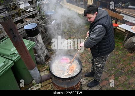 Ohrady, Dunajská Streda, Slowakei - 12. März 2022: Traditionelle Dorfgemeinde Schweineschlacht (zabíjačka), Mann rührt einen Dampftopf im Freien Stockfoto