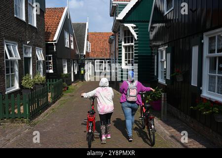 Marken, Niederlande - 25. August 2024: Menschen mit Fahrrädern im Dorf Marken. Stockfoto