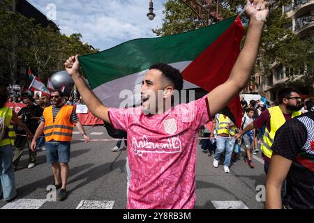 Barcelona, Spanien. Oktober 2024. Während der Kundgebung wird ein Demonstrant gesehen, der die palästinensische Flagge schwenkt. Tausende von Menschen haben im Zentrum Barcelonas demonstriert, um einen Waffenstillstand über Palästina und den Libanon zu fordern und den spanischen Premierminister Pedro Sánchez zu fordern, dass die spanische Regierung unverzüglich alle Zusammenarbeit beim Waffenverkauf an Israel einstellt. Quelle: SOPA Images Limited/Alamy Live News Stockfoto