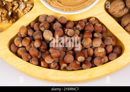 Erdnüsse, Walnüsse und Haselnüsse in einer Holzkiste mit Fächern. Drei verschiedene Arten von Muttern, geschalen und geschalen, dekoratives Sortiment und fertig Stockfoto