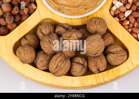 Erdnüsse, Walnüsse und Haselnüsse in einer Holzkiste mit Fächern. Drei verschiedene Arten von Muttern, geschalen und geschalen, dekoratives Sortiment und fertig Stockfoto