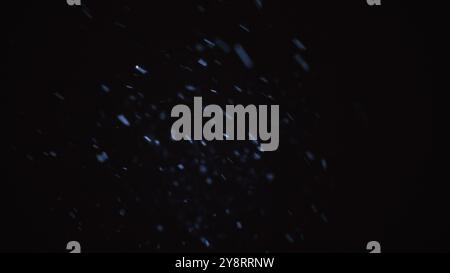 Bokeh Regen Hintergrund. Unscharfe, leuchtende Textur. Schneefall-Effekt für den Übergang. Defokussiertes Neonlila Licht fliesst in dunkler schwarzer Nacht in Bewegung Stockfoto