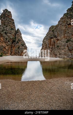 SA Calobra, Mallorca Strand zwischen felsigen Bergwänden bei bewölktem Wetter, See vor dem, vertikaler Schuss, mallorca Stockfoto