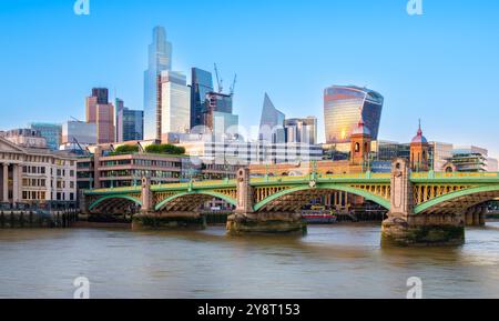 London, Großbritannien - 25. Juni 2024: Ein pulsierendes Stadtbild Londons mit modernen Wolkenkratzern entlang der Themse, die das warme Leuchten reflektieren Stockfoto