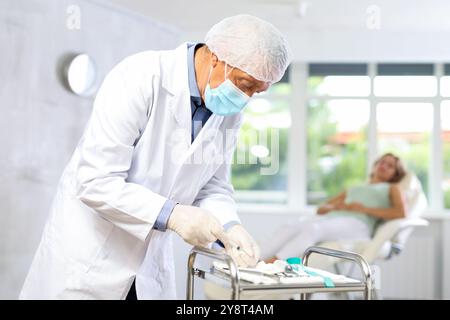 Konzentrierter, älterer Arzt, der die Spritze für die Injektion vorbereitet Stockfoto
