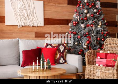 Stilvolle Einrichtung des modernen Wohnzimmers mit weihnachtlicher Einrichtung und brennenden Kerzen Stockfoto