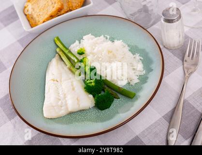 Fleisch von gebackenem Kabeljaufilet wird mit gekochtem Reis garniert, dekoriert mit gekochtem Brokkoli und Spargel Stockfoto