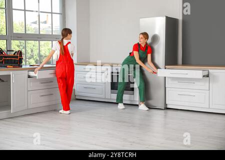 Weibliche Arbeiter, die in der Küche Ablagefächer zusammenbauen Stockfoto