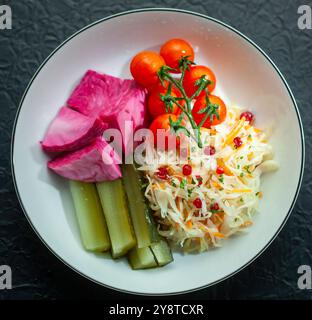 Weiße Platte mit fermentiertem Gemüse und Gurken Stockfoto