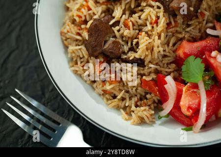 Dampfplatte mit aromatischem Reispilaw mit Fleisch und Gemüse Stockfoto