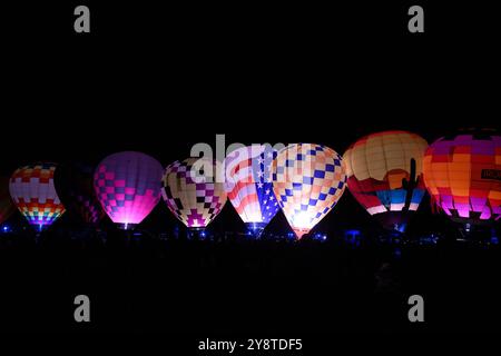 Albuquerque, Usa. Oktober 2024. Eine Reihe von Ballonen leuchtet, während sie während der 52. Jährlichen Albuquerque International Balloon Fiesta im Balloon Fiesta Park am 6. Oktober 2024 in Albuquerque, New Mexico, abgefeuert werden. (Foto: Sam Wasson/SIPA USA) Credit: SIPA USA/Alamy Live News Stockfoto