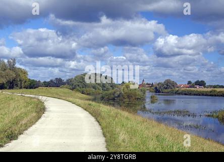 Ein schmaler Weg entlang eines Flusses mit Blick auf mehrere Häuser und Bäume, Schnackenburg die kleinste Stadt Deutschlands, Elbe, Wendland, Niedersachsen, Deutschland Stockfoto