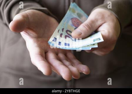 Weißer Mann zeigt Euro-Geld zwanzig Scheine aus der Nähe in seinen Händen Stockfoto