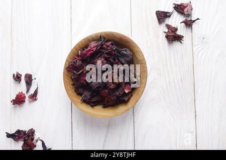 Ansicht von oben an der hölzernen Schüssel trocken Hibiscus Blüten auf weißem Hintergrund Stockfoto