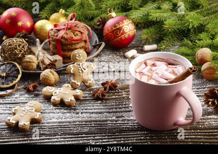 Weihnachten Hintergrund rosa Tasse heiße Schokolade mit Marshmallows, fichte Zweig und Fach mit Lebkuchen Cookies auf hölzernen Tisch Stockfoto