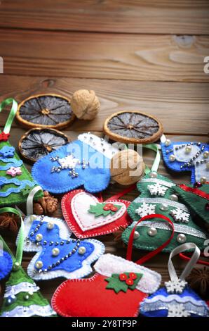 Verschiedene handgefertigte rustikalen fühlte Christbaumschmuck mit Anis, Zimt und Walnüssen auf hölzernen Tisch Stockfoto