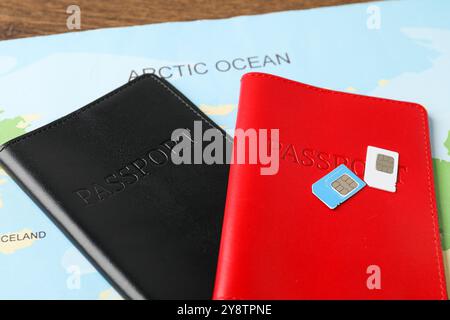 Pässe, SIM-Karten und Weltkarte auf dem Tisch Stockfoto