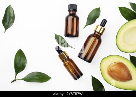 Tropfflaschen mit frischer reifer Avocado und ätherischem Öl auf weißem Tisch flach legen Stockfoto