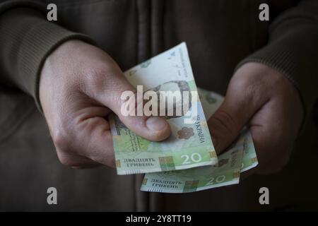 Weißer Mann, der ukrainische Geldscheine aus der Nähe gibt Stockfoto