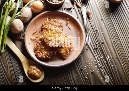 Draufsicht bei Flach frische, hausgemachte leckere Kartoffelpuffer in Ton Gericht mit Apfelmus Stockfoto