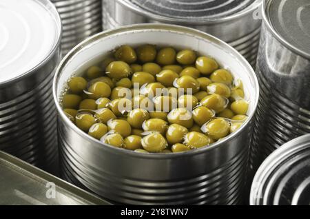 Grüne Erbsen in der Dose in der gerade geöffneten Dose. Nicht verderbliche Lebensmittel Stockfoto