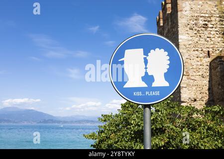 Kuss-Straßenschild im öffentlichen Bereich vor Schloss Sirmione, Italien. Das Konzept der Liebe, des Paares, der Romantik Stockfoto