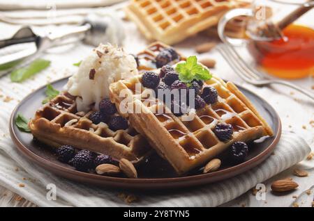 Hausgemachte knusprige belgische Waffeln, serviert mit Brombeeren, Honig und Eiscreme Stockfoto