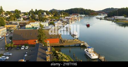 Am späten Nachmittag Sonnenlicht schlägt die Waterfront als rotes Boot passiert vor La Conner Washington Stockfoto